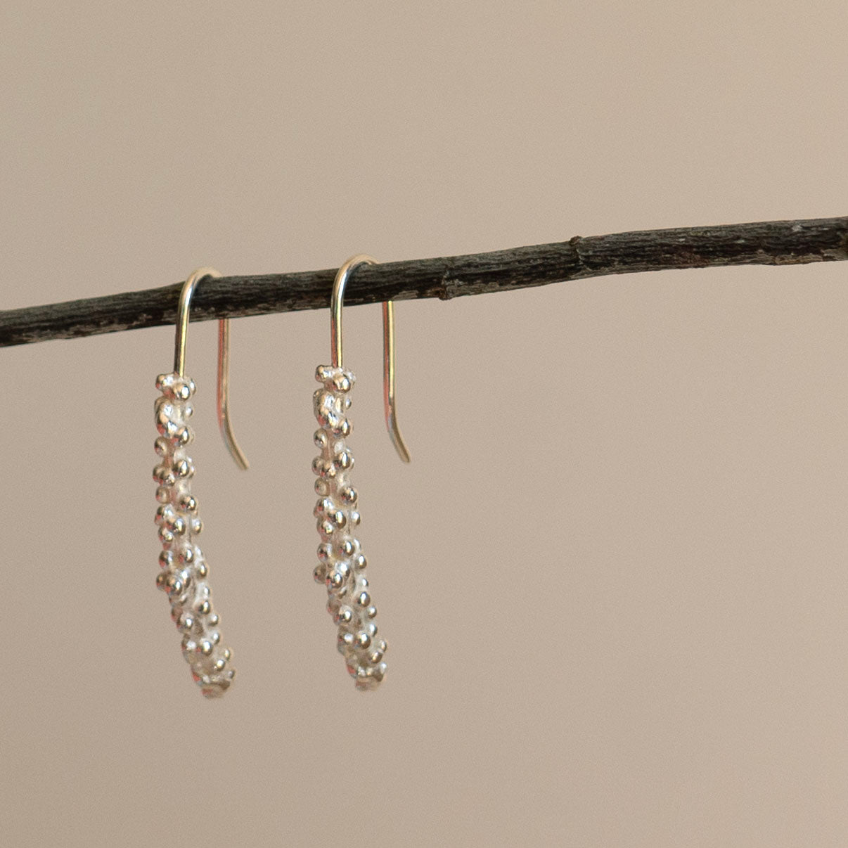 Silver millet stick drop earrings