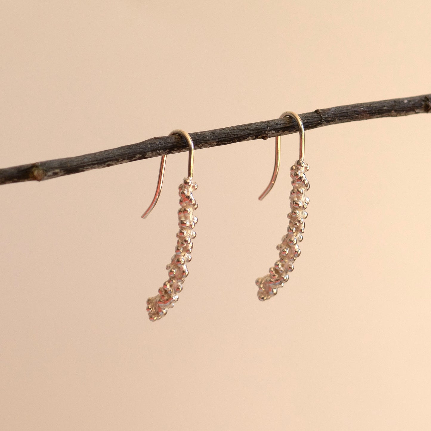 Silver millet stick drop earrings