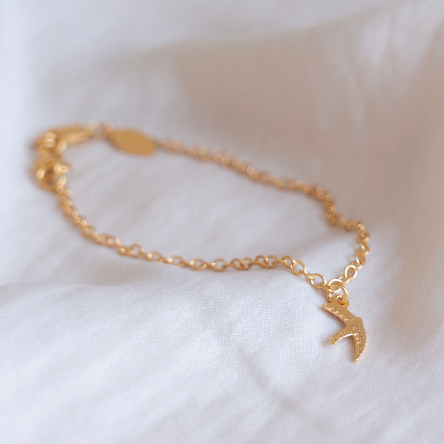 Gold swift charm bracelet