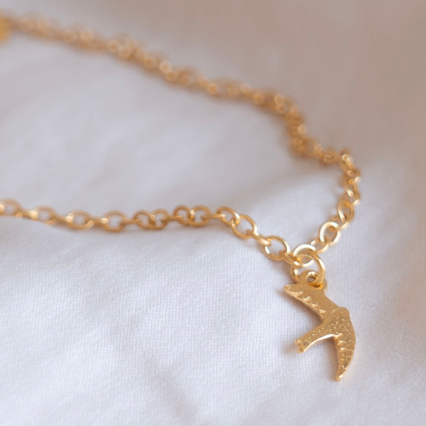 Gold swift charm bracelet